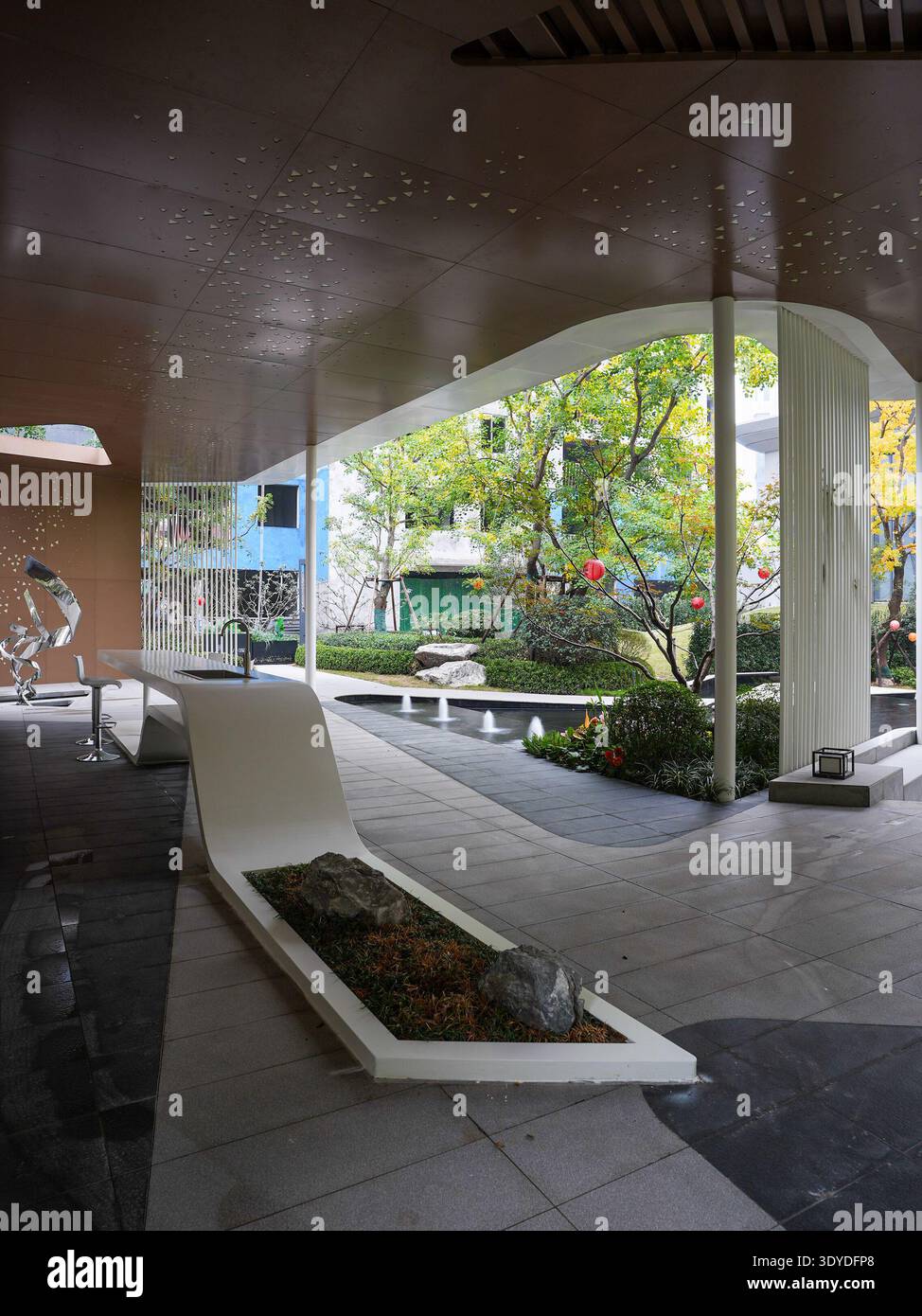 Blick durch moderne Bauelemente in einen wunderschön angelegten Zen-Garten. Das Bild vermittelt architektonischen Rahmen, Naturintegration, Stockfoto