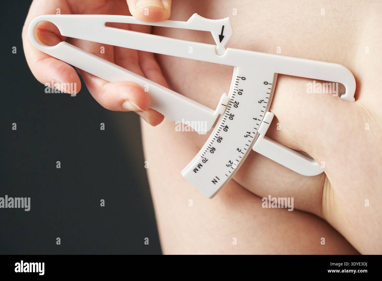 Weibliche Hand Körperfettmessung mit Messschieber am hautnahen Analysetool. Stockfoto