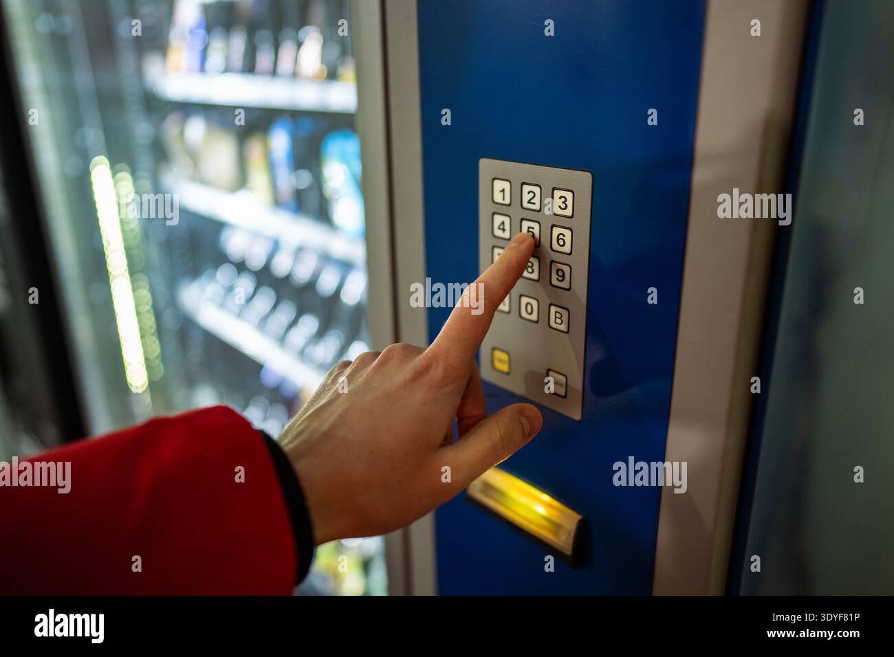Mann-Kunde, der kalte Getränke aus dem Automaten in der Stadt kauft und Tasten auf der Tastatur drückt. Stockfoto