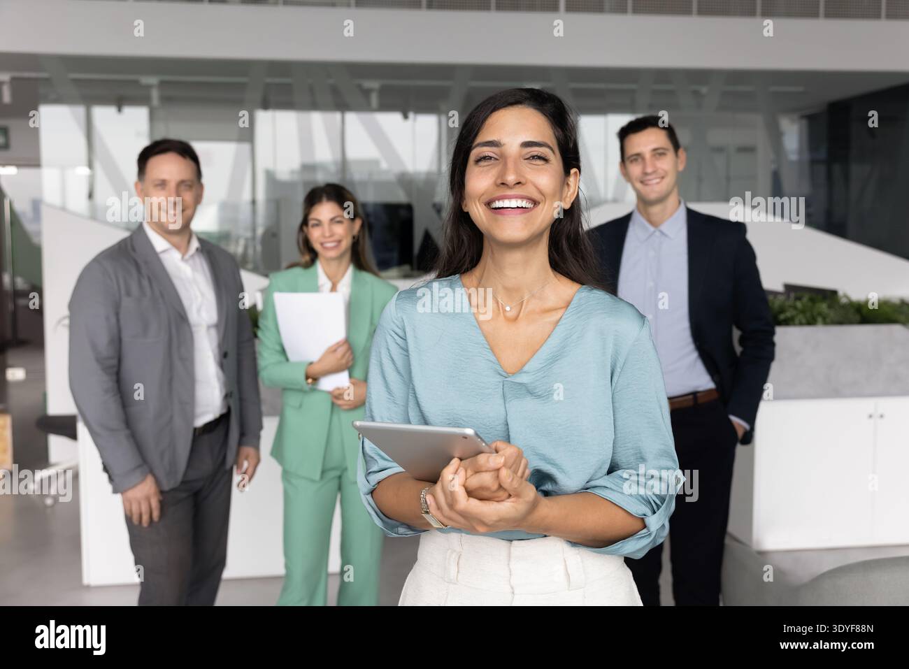 Weibliche Führerin, die vor einem multiethnischen Team im Amt steht Stockfoto