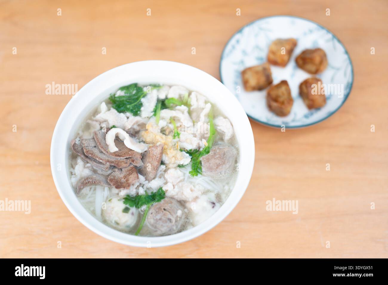 Kantonesische Rindernudelsuppe mit Knödeln auf Holztisch in Guangzhou Stockfoto