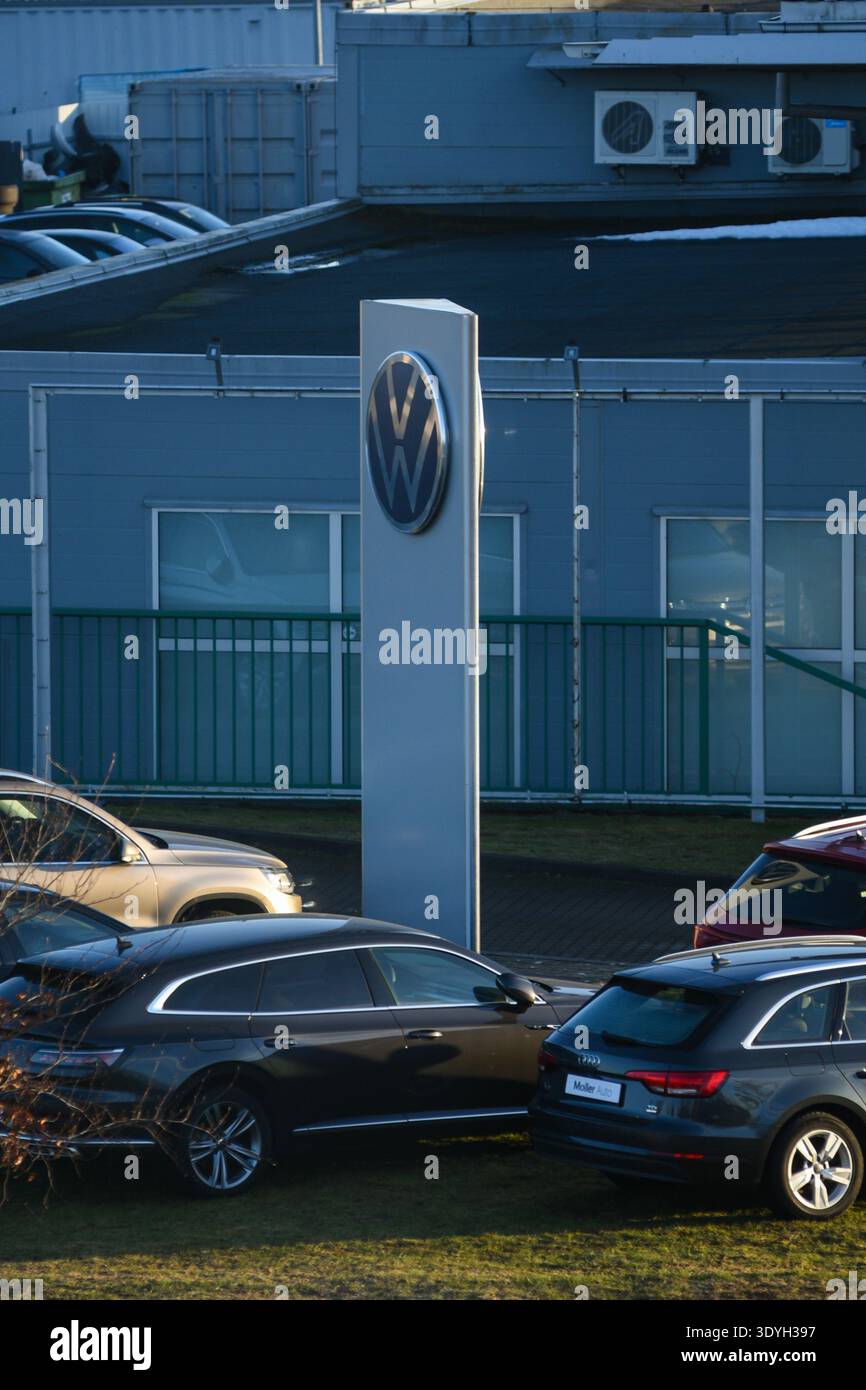 Ventspils, Lettland - 5. März 2026: Schild des Volkswagen-Händlers über geparkten Fahrzeugen an einem modernen Autohändlerstandort. Fahrzeugeinzelhandel Stockfoto