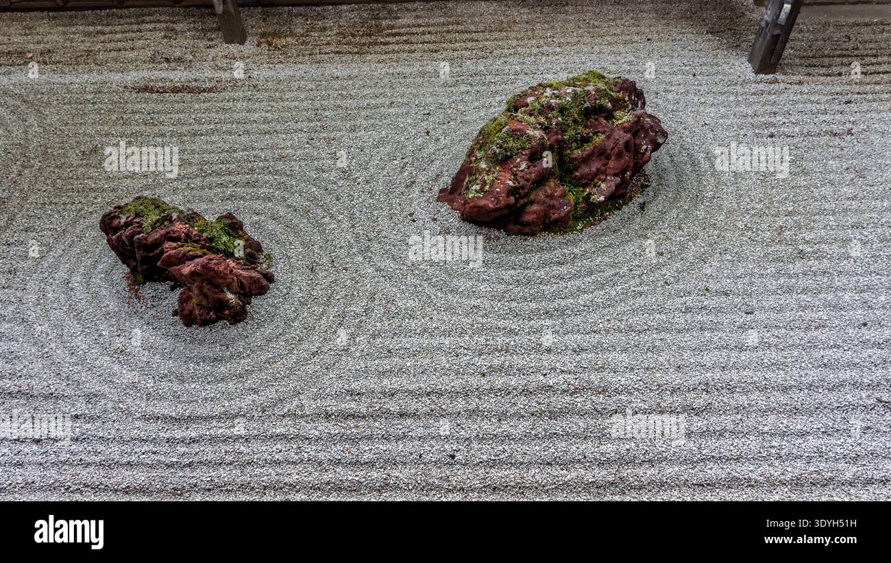Sorgfältig angeordnete Felsen umgeben von geharktem Kies in einem traditionellen japanischen Zen-Garten in Koyasan, Japan, die die minimalistische Ästhetik und veranschaulichen Stockfoto