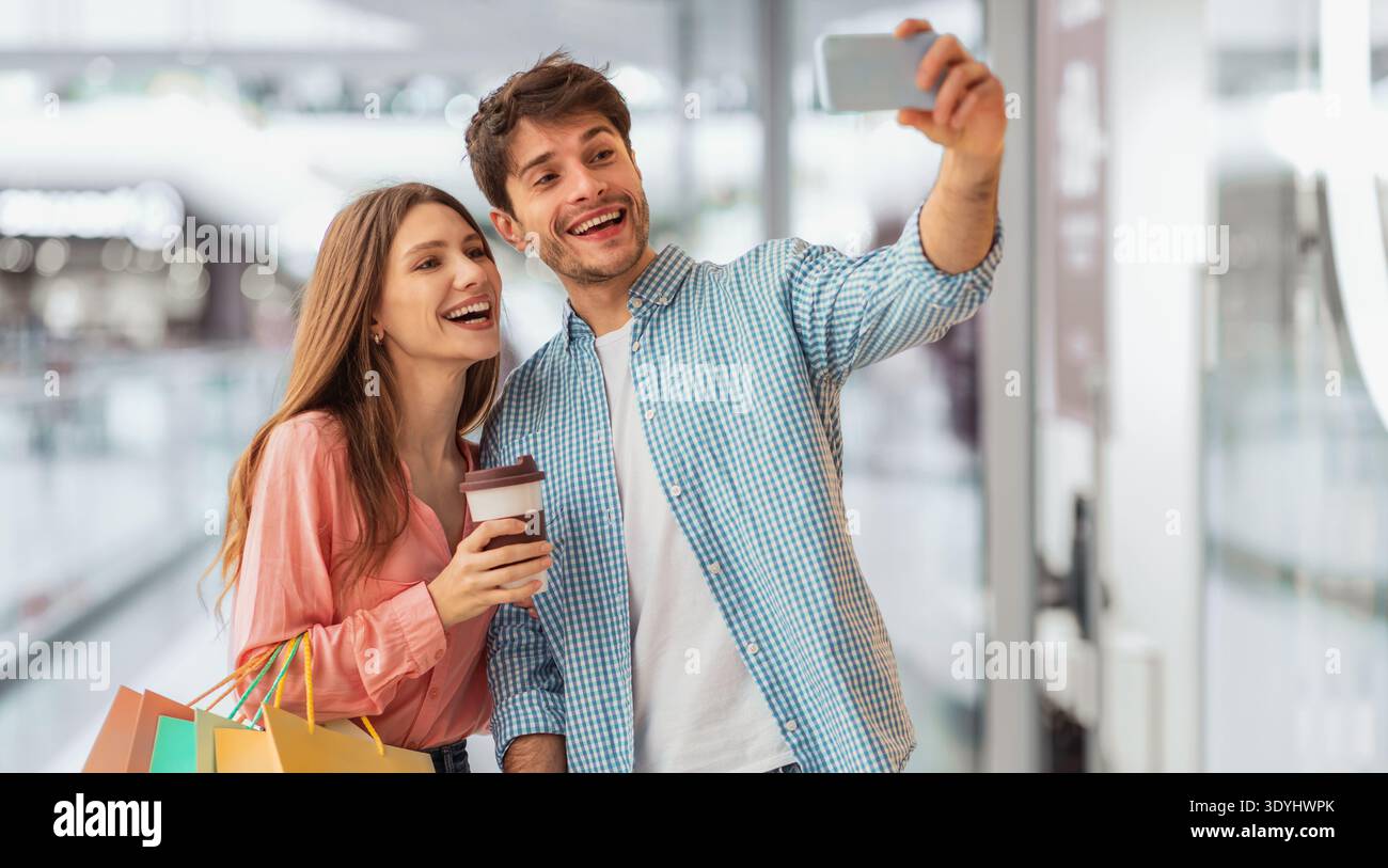 Happy Pärchen nimmt Selfie nach einem erfolgreichen Einkaufstag in die Shopping Mall Stockfoto