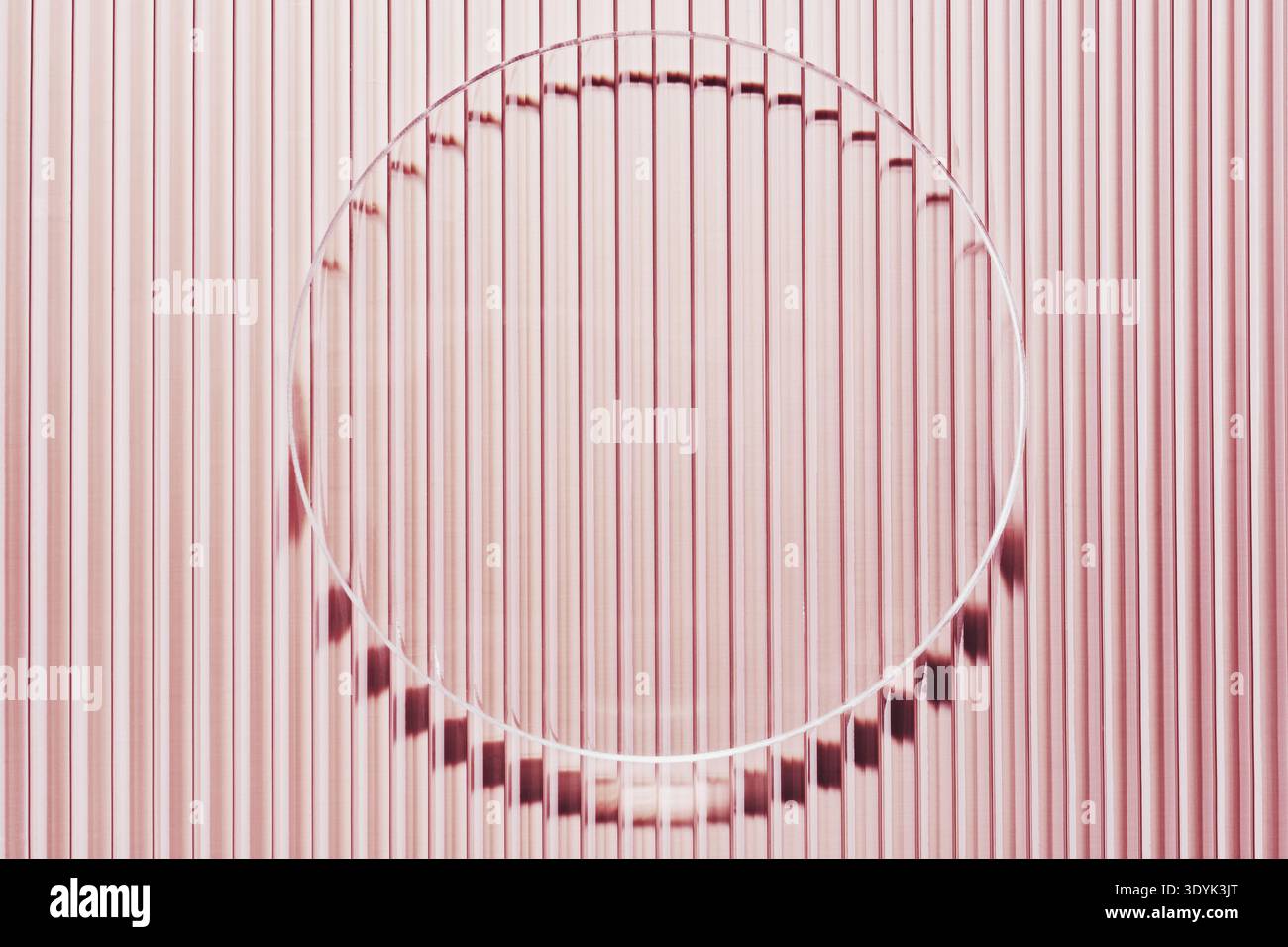 Abstrakte Textur eines rosa gerippten Hintergrunds, durchzogen von einem reflektierenden Kreis Stockfoto