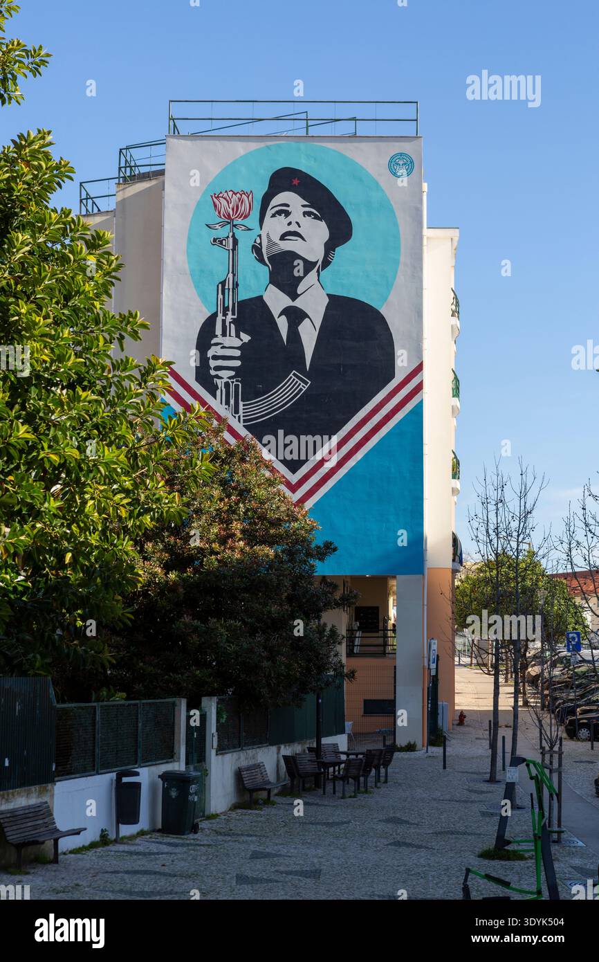 Großes Street Art Wandgemälde in Lissabon, Portugal, das einen Soldaten mit einer Nelke in einem Gewehr darstellt, um die historische Nelkenrevolution zu feiern. Stockfoto