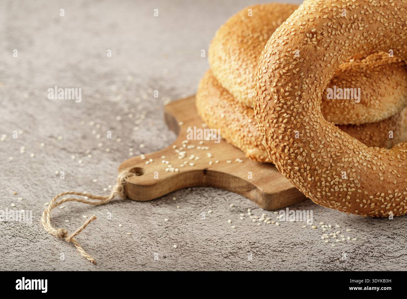 Traditionelle türkische Simit Sesam Bagels auf Holzbrett auf Steintisch Stockfoto