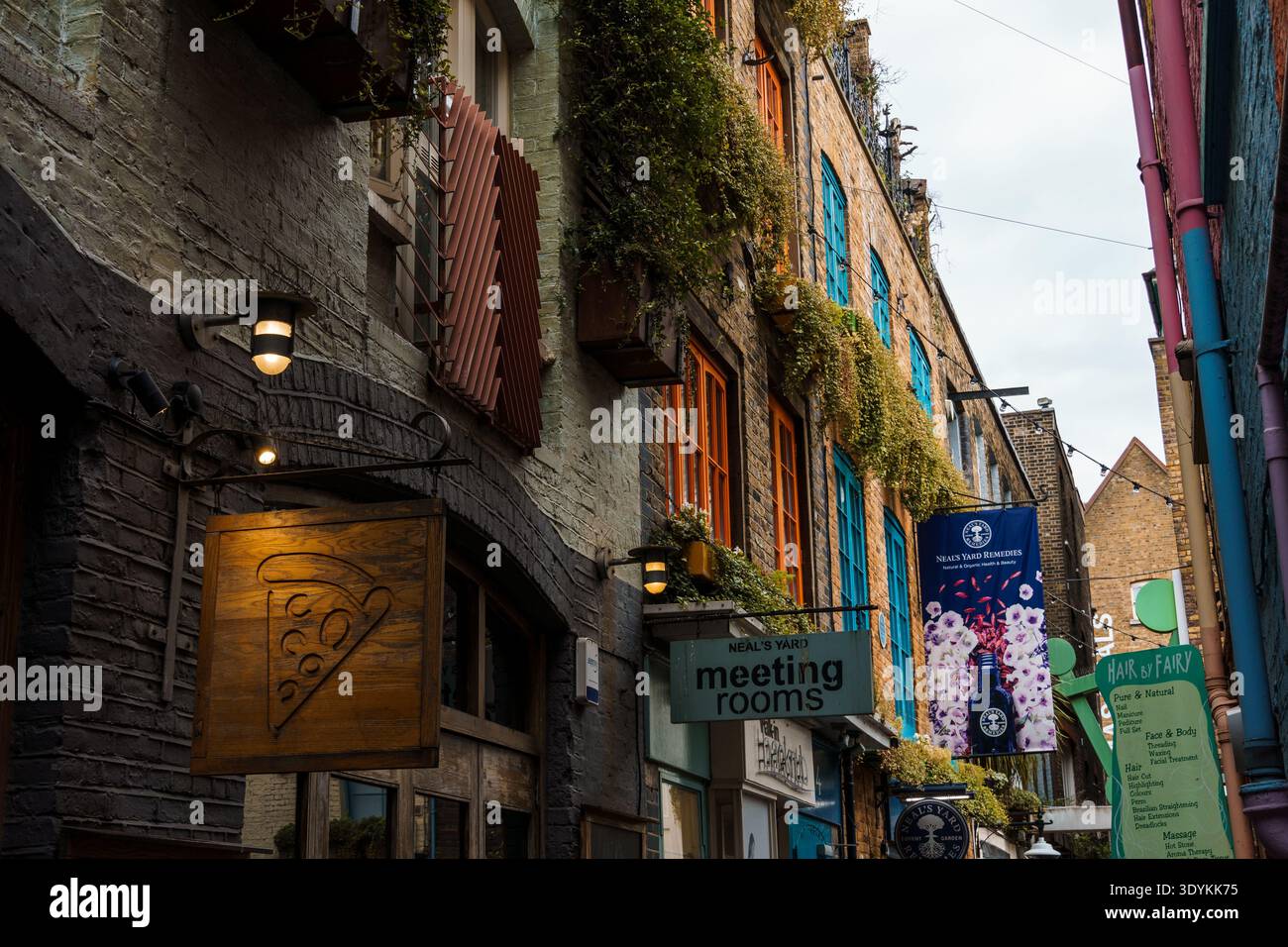 London, Großbritannien - 27. August 2023: Eine bezaubernde Gasse in Covent Garden, Neal Yard, mit farbenfrohen Gebäuden, Ladenschildern und hängenden Pflanzen. Stockfoto