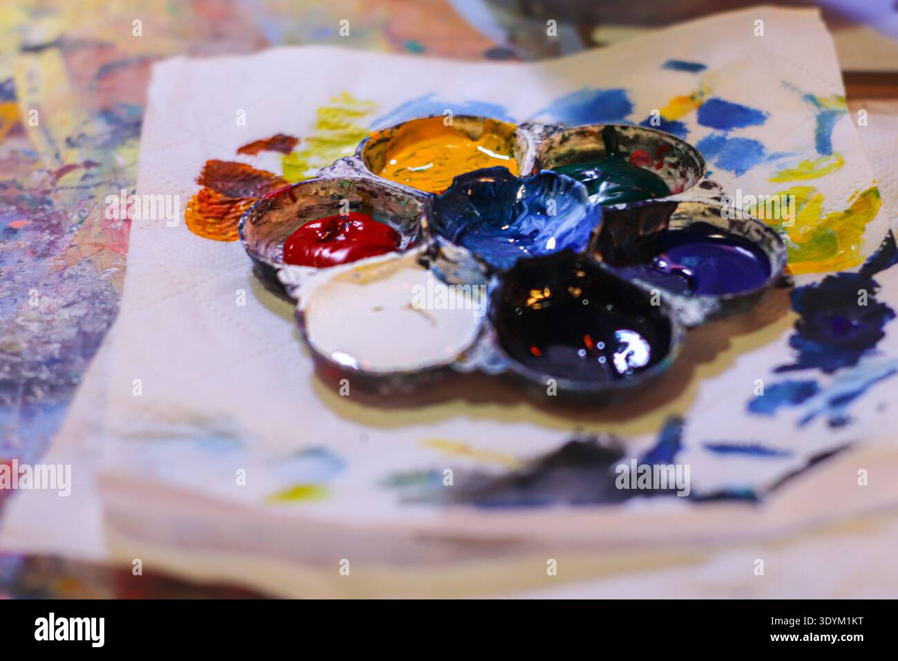 Farbenfrohe Farbpalette auf Papier, die kreatives Chaos und künstlerischen Ausdruck in einer lebendigen Komposition zeigt. Stockfoto