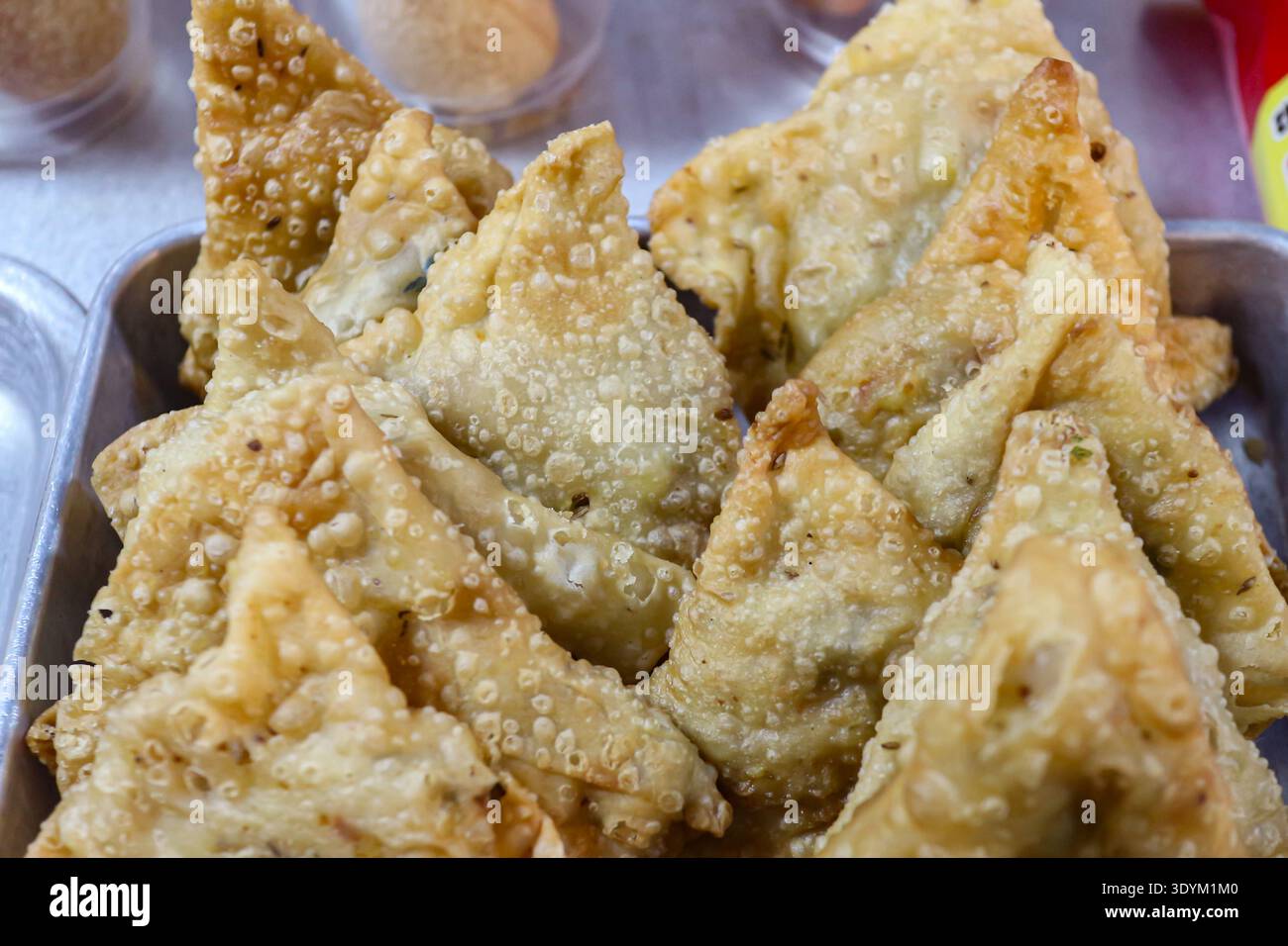 Schließen Sie gebratene Samosas mit goldener Kruste in einem Street Food-Stand, der authentische asiatische Snacks und Komfort-Gerichte repräsentiert. Stockfoto
