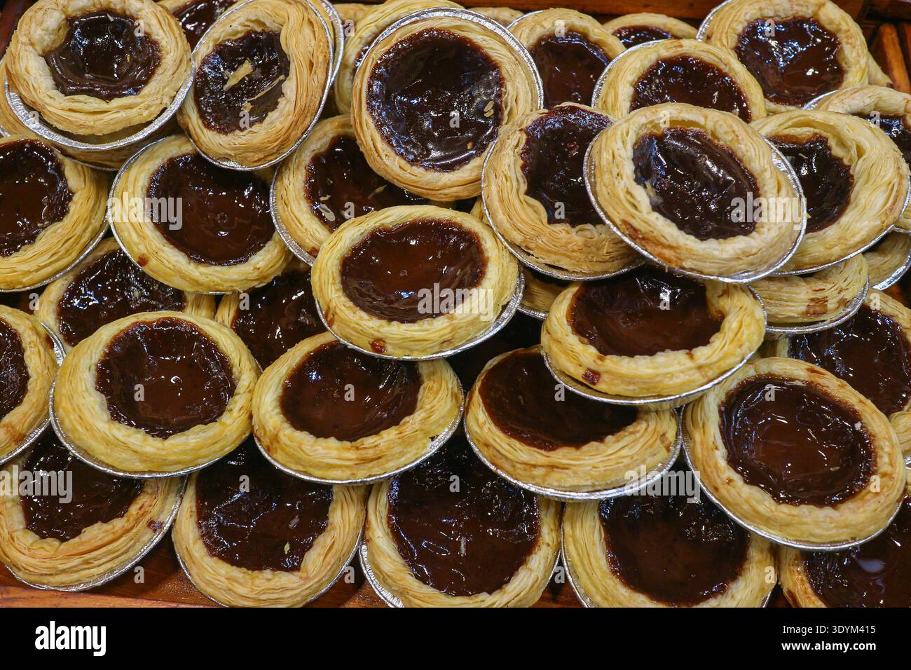 Schokoladen-Eierkuchen mit blättrigen Teigschichten und karamelisierten Platten, die eine erstklassige Backwaren-Desserttextur in der Draufsicht zeigen. Stockfoto