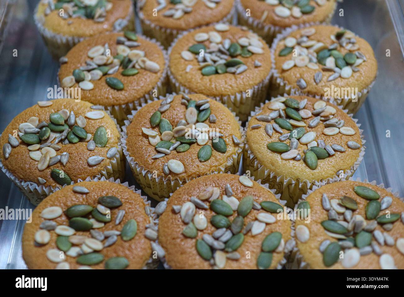 Nahaufnahme von Vollkorn-Muffins mit gemischten Samen einschließlich Kürbis- und Sonnenblumenkernen in einer gesunden Bäckerei. Stockfoto