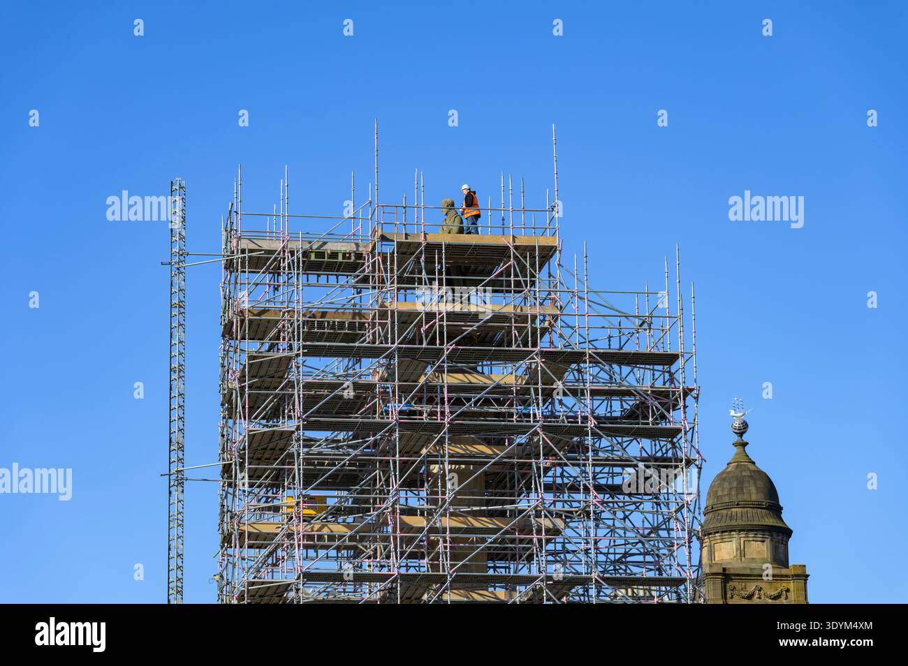 Eine Person, die auf dem Gerüst um die Sir Walter Scott Statue während der Renovierung am George Square, Glasgow, Schottland, Großbritannien, läuft Stockfoto