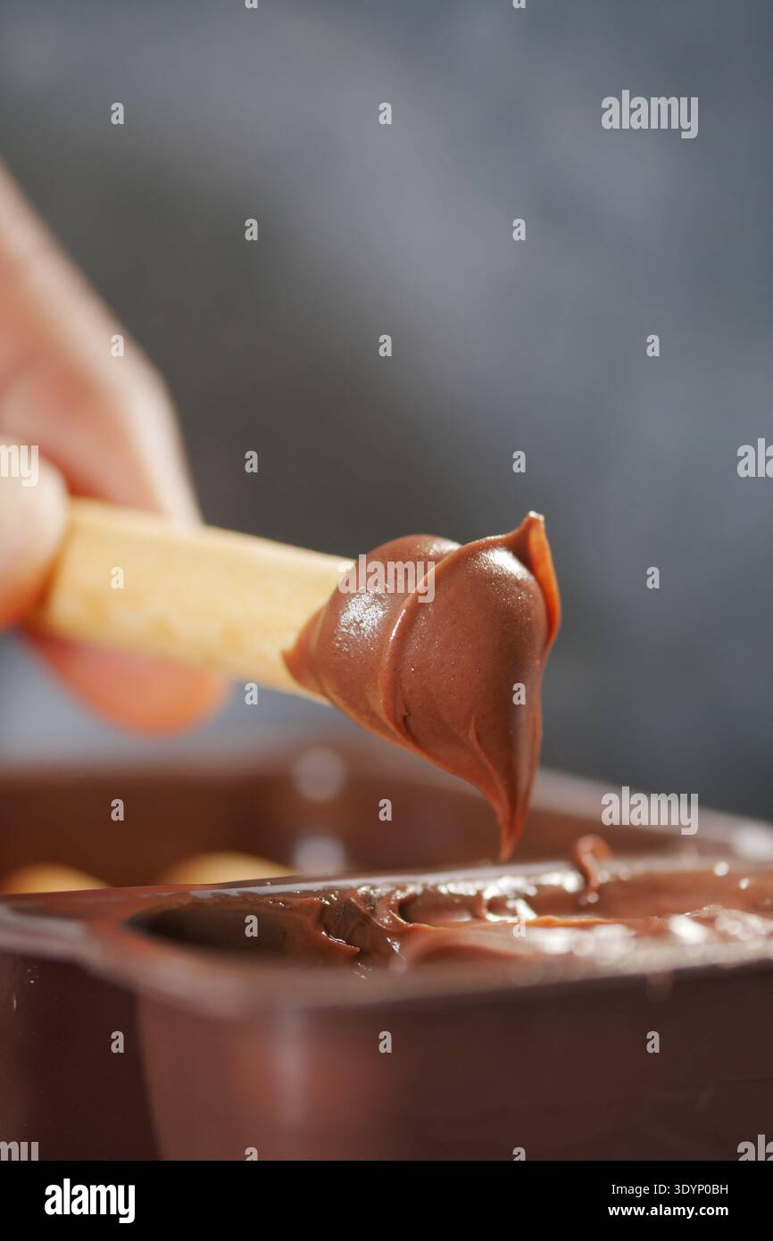 Schokolade mit einem Stock in der Hand zu Hause genießen Stockfoto