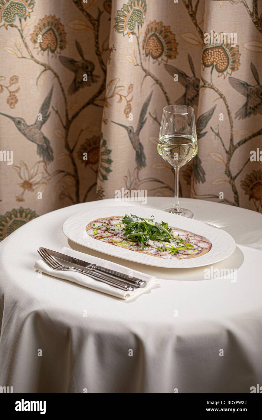 Octopus carpaccio mit Rucola und Parmesan Stockfoto