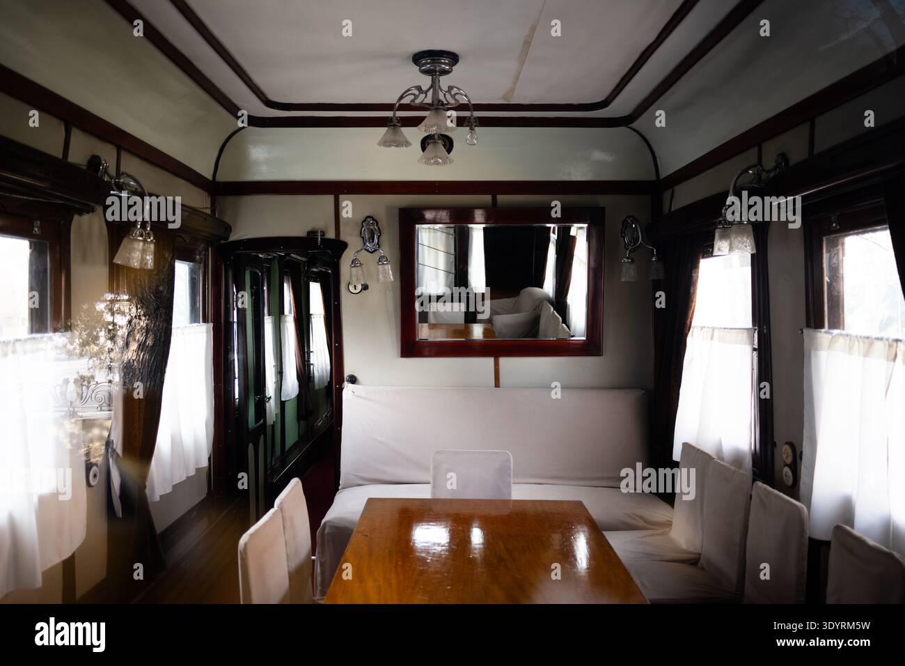 Innenraum von Joseph Stalins privatem Zugwagen mit Vintage-Holztisch, gepolsterten Sitzgelegenheiten und klassischer Beleuchtung, Georgia. Stockfoto