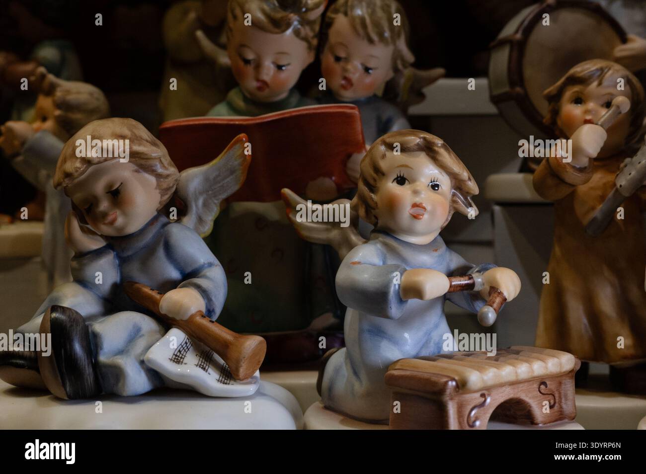 Sammlung von handgefertigten Figuren, die Kinder und Engel darstellen, die Musikinstrumente spielen, angeordnet als dekorative Ornamente mit einem nostalgischen und einem Stockfoto
