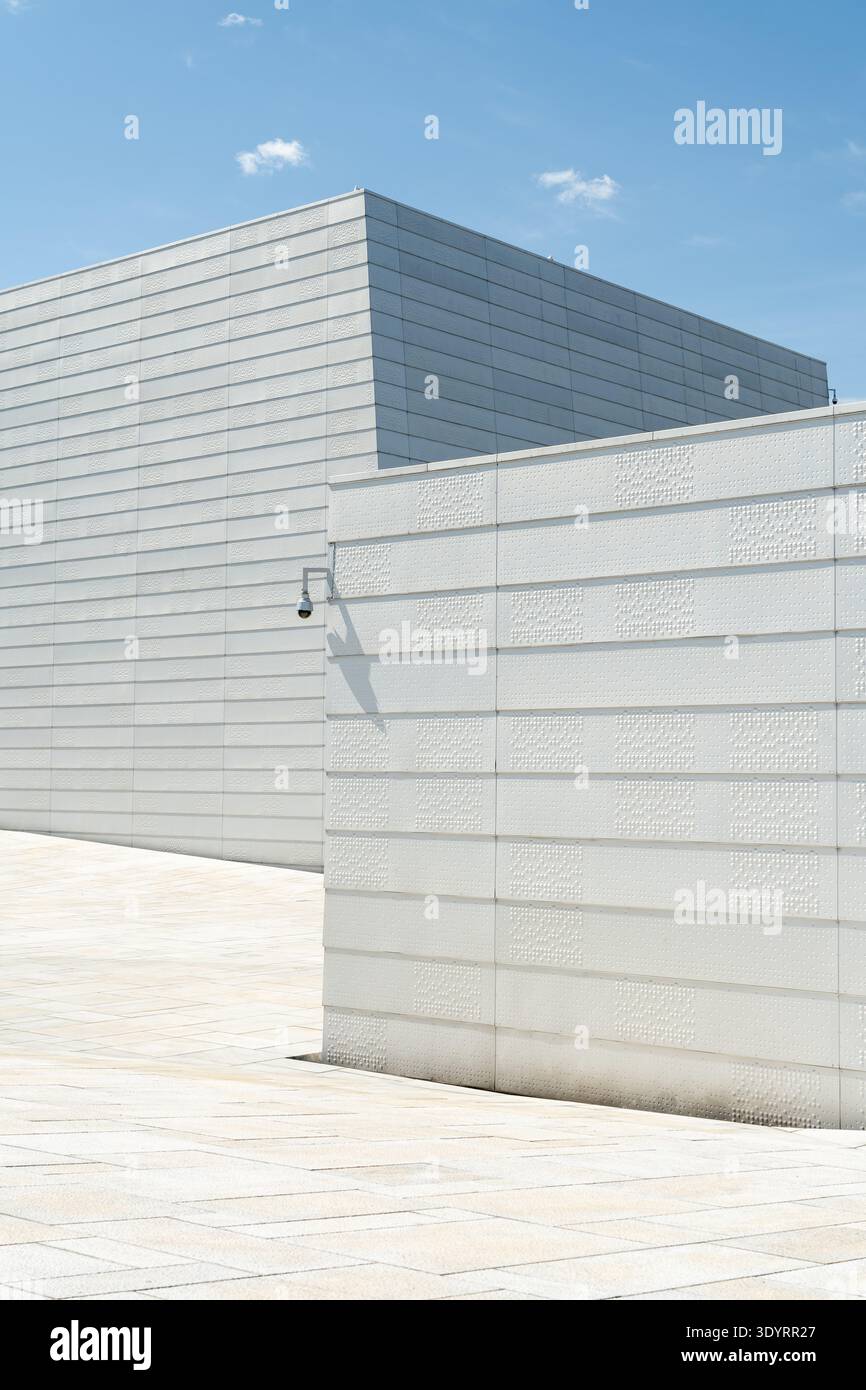 Blick auf die minimalistische Architektur mit scharf weißen Wänden des Opernhauses Oslo unter einem hellblauen Himmel, die eine ruhige und moderne Ästhetik schaffen, OSL Stockfoto