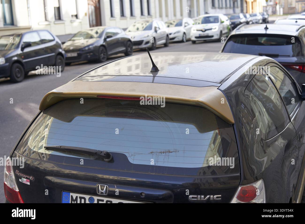 Schwarzer Honda Civic Fließheck mit goldenen Akzenten auf einer städtischen Straße Stockfoto
