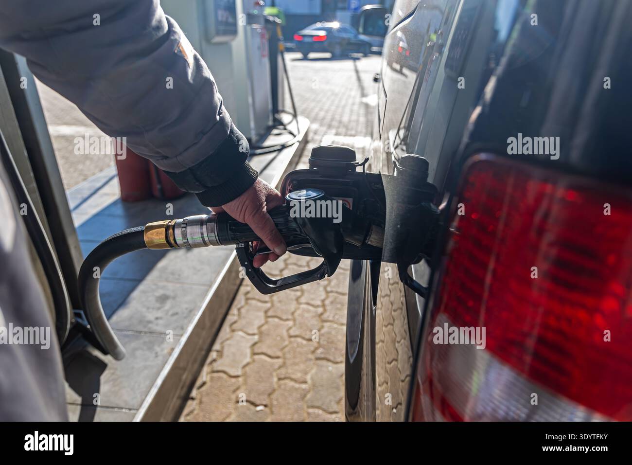 Person, die das Auto an der Tankstelle betankt. Nahaufnahme einer Person, die ein Auto an einer Tankstelle mit Kraftstoff betankt, zeigt den Tankvorgang, den Transport, die Energie Stockfoto