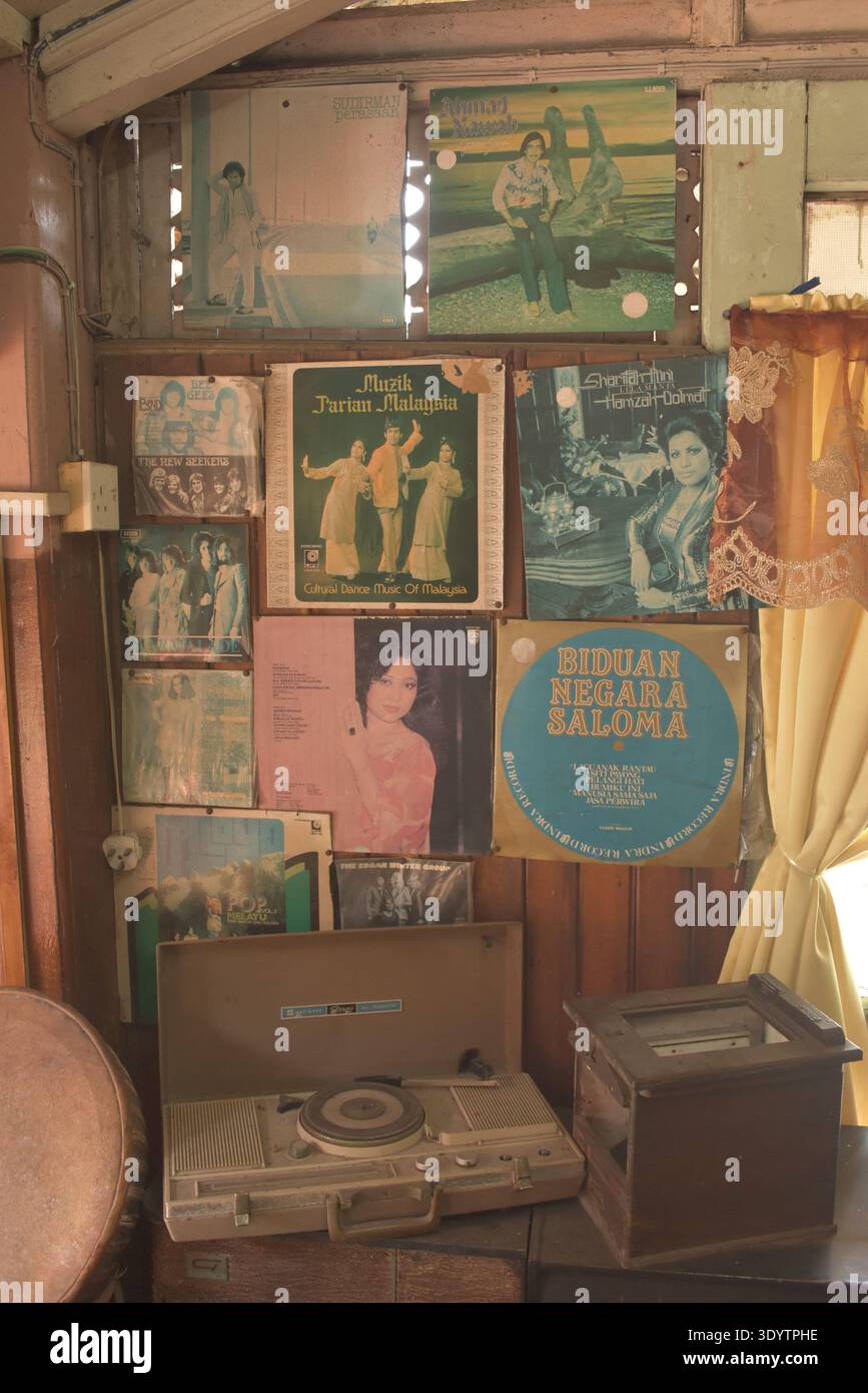 Inneneinrichtung mit einem Vintage-Plattenspieler und einer Wandwand mit klassischen Vinyl-Albumcovern einschließlich malaysischer Künstler Stockfoto