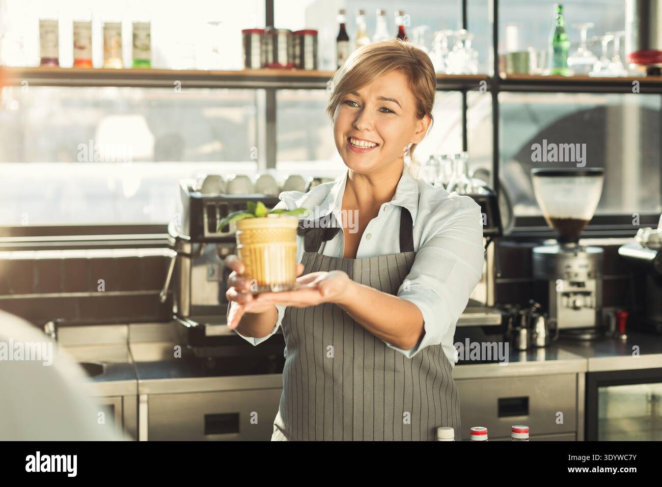 Glücklicher Barkeeper, der am Café-Theke Kaffee-Cocktail gibt Stockfoto