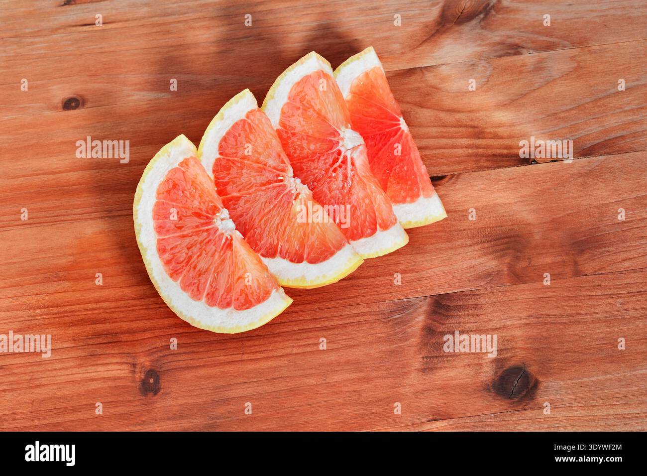 Scheiben rosafarbener, reifer Grapefruits, die auf Holztisch gegessen oder gekocht werden können Stockfoto