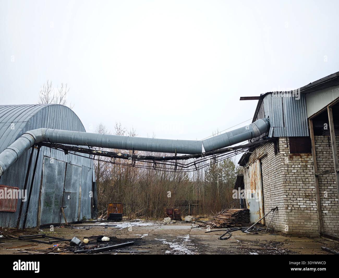 Ein leerer Industriehof mit Silos und Rohren veranschaulicht den Rückgang der postsowjetischen Infrastruktur im ländlichen Russland. Stockfoto