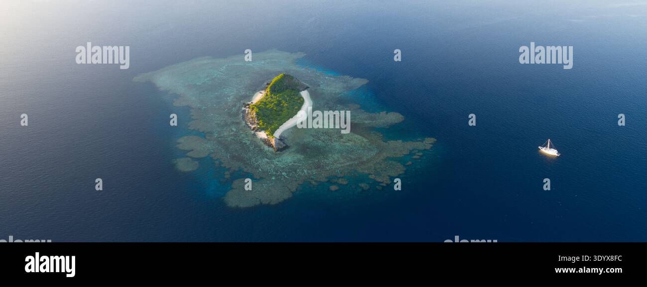 Ein flaches Korallenriff befindet sich rund um eine malerische Insel im Bligh Channel in Fidschi. Fidschis wunderschöne Korallenriffe unterstützen eine hohe biologische Vielfalt der Meere. Stockfoto