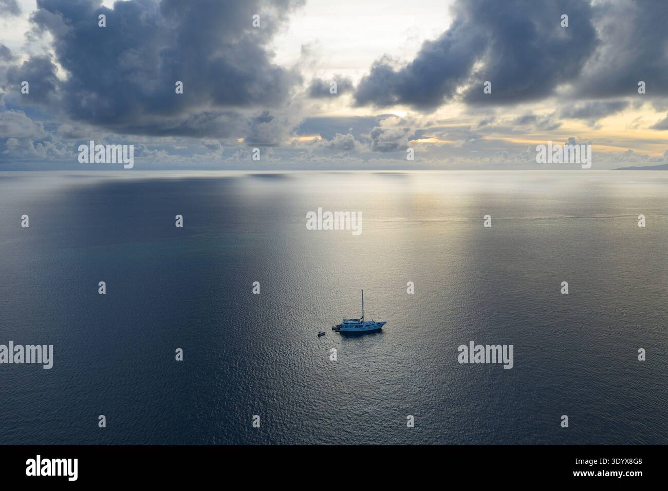 Bei Sonnenaufgang liegt ein kleines Schiff vor Anker in einem abgelegenen Teil von Fidschi. Diese wunderschöne Gegend ist bekannt für ihr warmes, tropisches Klima. Stockfoto
