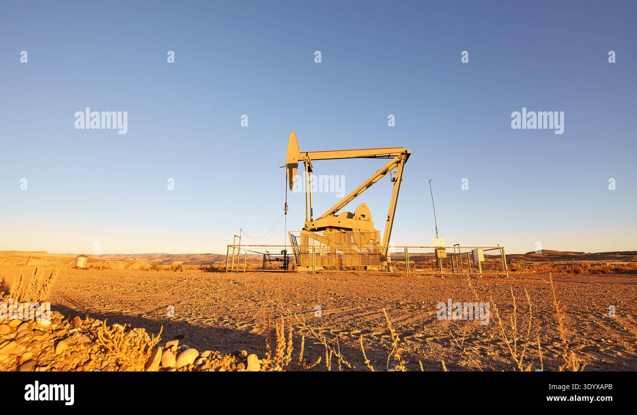 Pumpwagenheber (nickender Esel) in einer Wüste bei Sonnenuntergang. Stockfoto