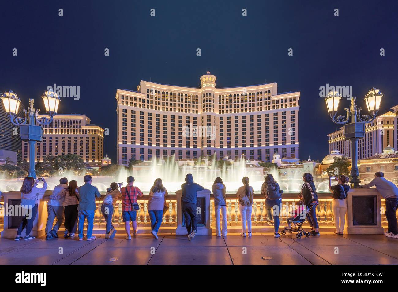 Die Gäste genießen den Blick auf die Springbrunnen im Bellagio Hotel and Casino bei Nacht in Las Vegas, Nevada. Stockfoto