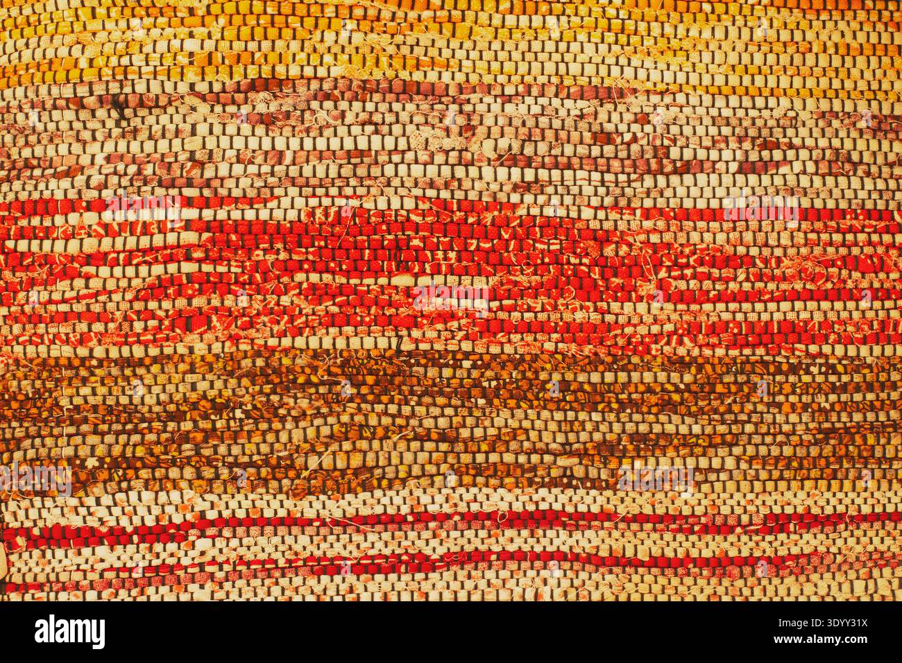 Detaillierte Makrostruktur des horizontalen gewebten Teppichs in warmen Herbstfarben Stockfoto