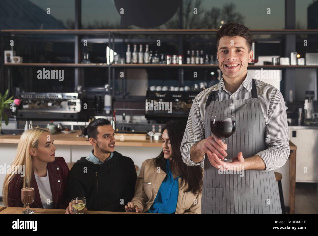 Ein lächelnder Kellner hält einen Kaffee-Cocktail Stockfoto