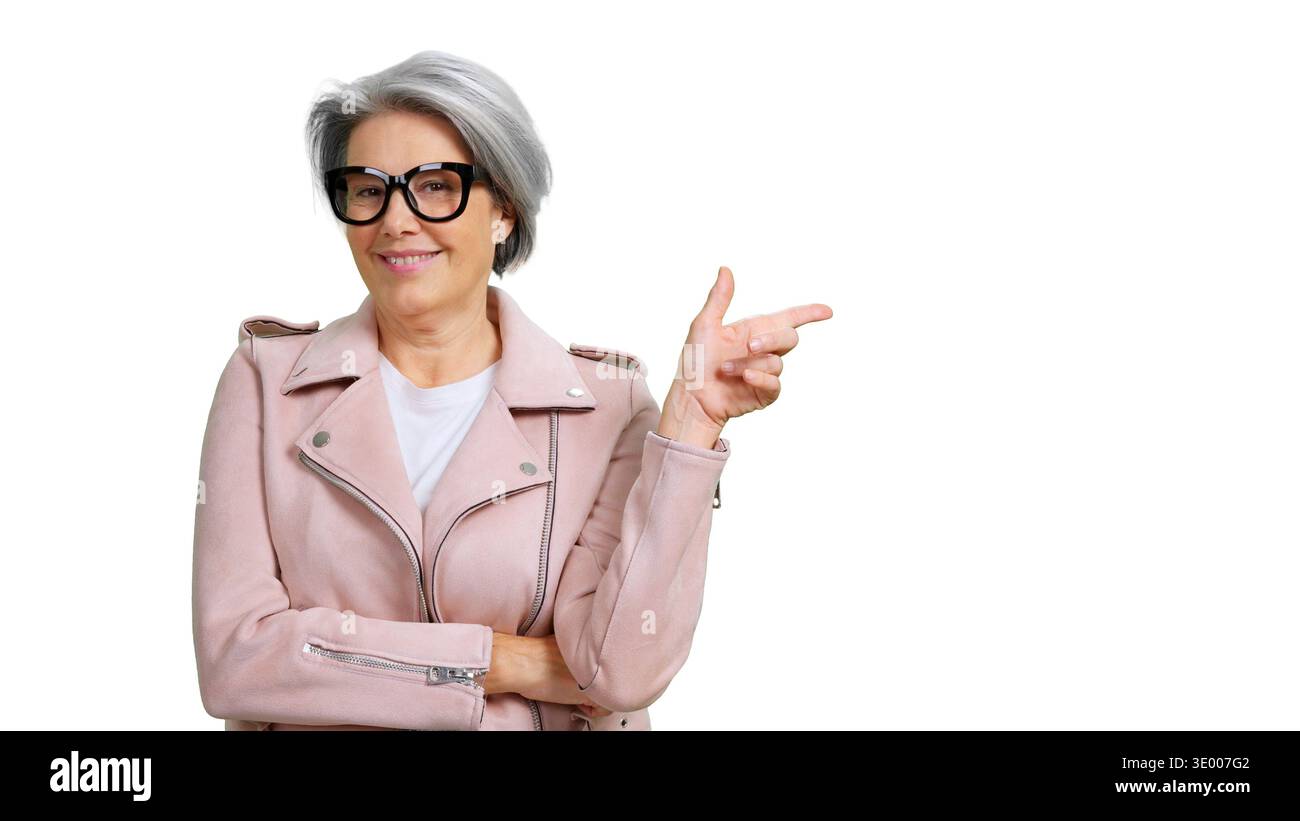 Reife Frau lächelt mit dem Zeigefinger und zeigt Kopierraum Stockfoto