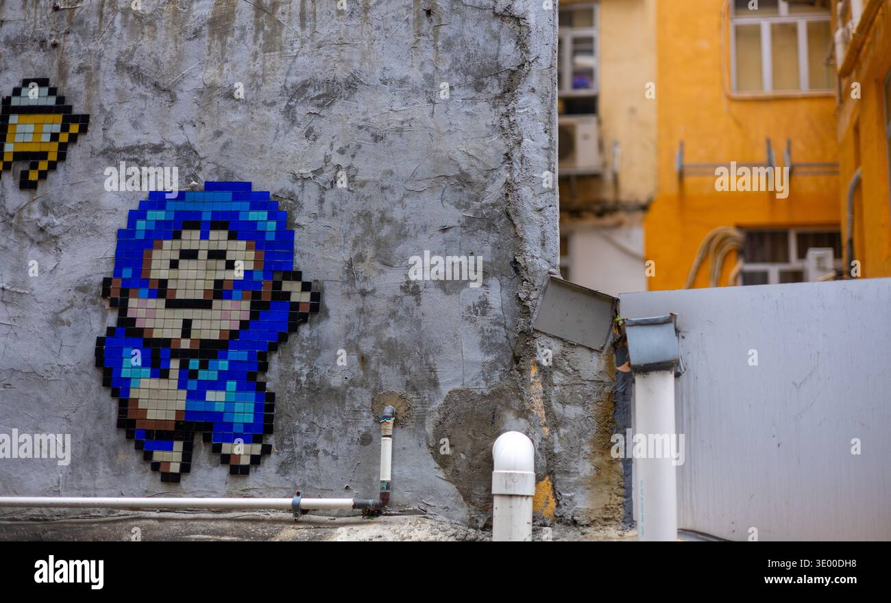 Keramikfliesen Pixel Mosaik Street Art des Künstlers Invader auf einer verwitterten Betonwand in Wan Chai – nur redaktionelle Verwendung – enthält urheberrechtlich geschützte Kunstwerke Stockfoto