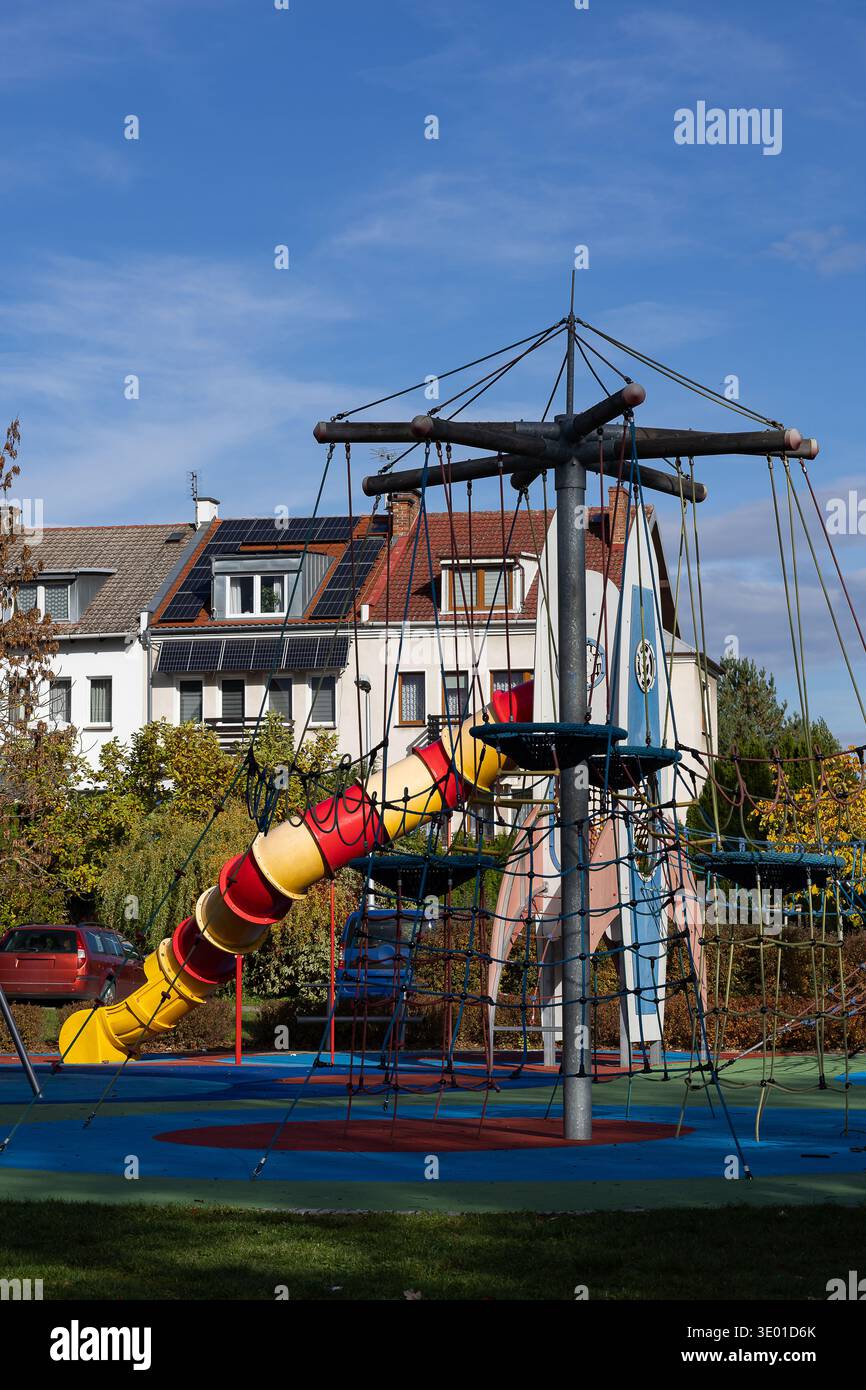 Architektonische Integration eines raketenförmigen Spielplatzes in ein modernes Wohnviertel mit Solarpaneelen auf Dächern. Stadtplanung Stockfoto