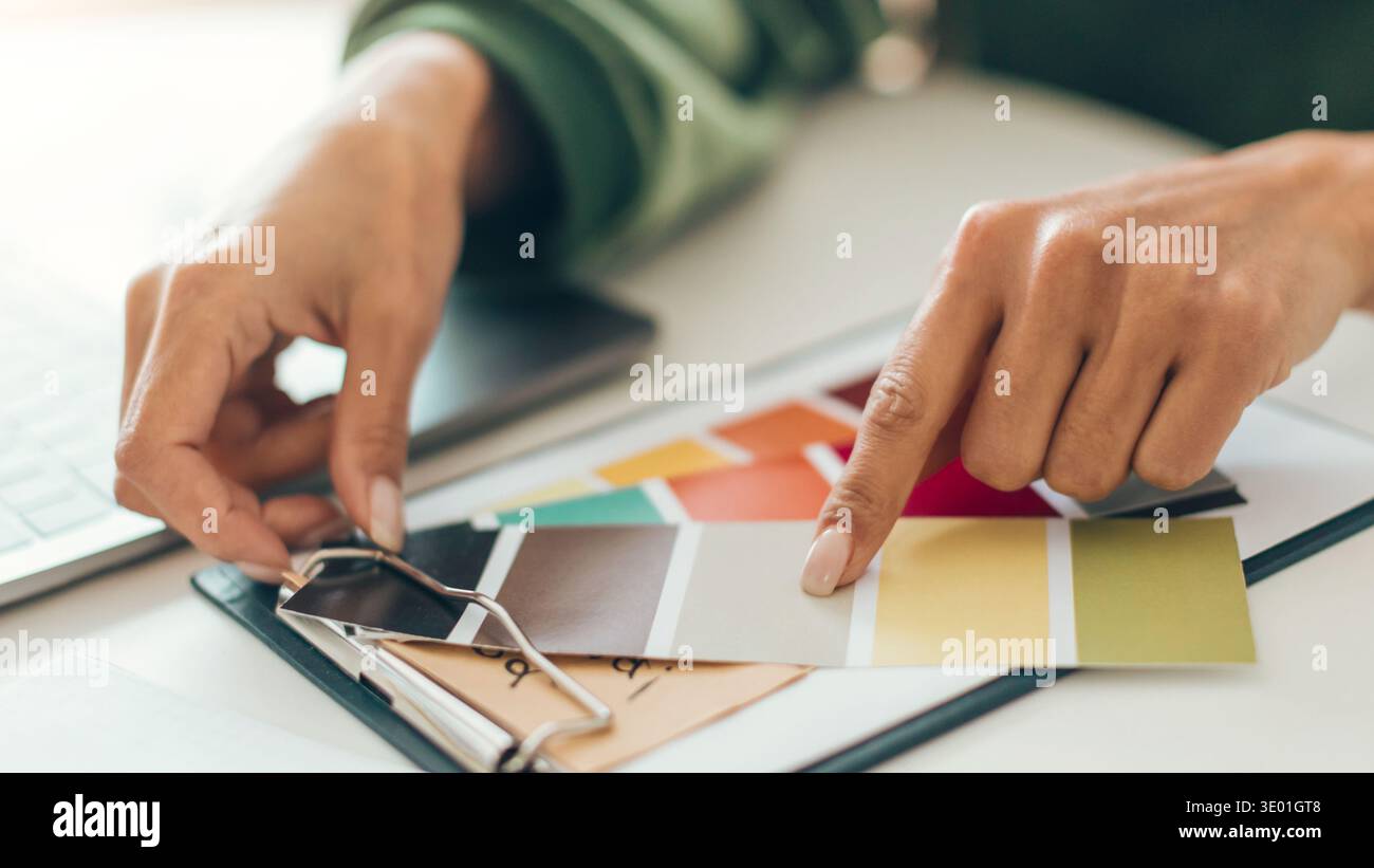 Wählen Sie Farben für ein Home-Projekt in einer Workspace-Einstellung an einem sonnigen Tag aus Stockfoto
