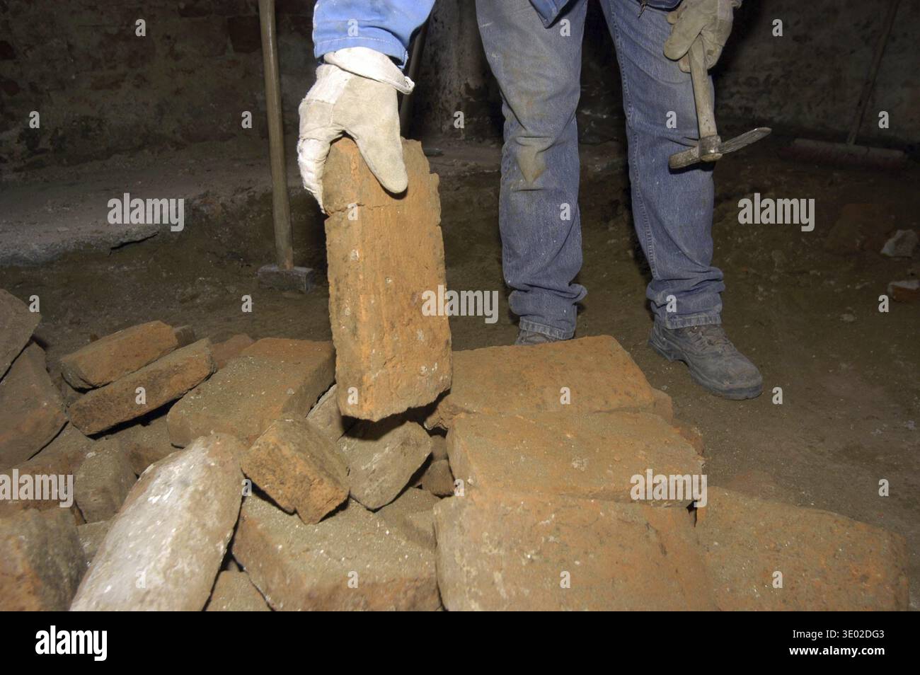 Mason baut eine Ziegelmauer und baut auf einer Baustelle Stockfoto