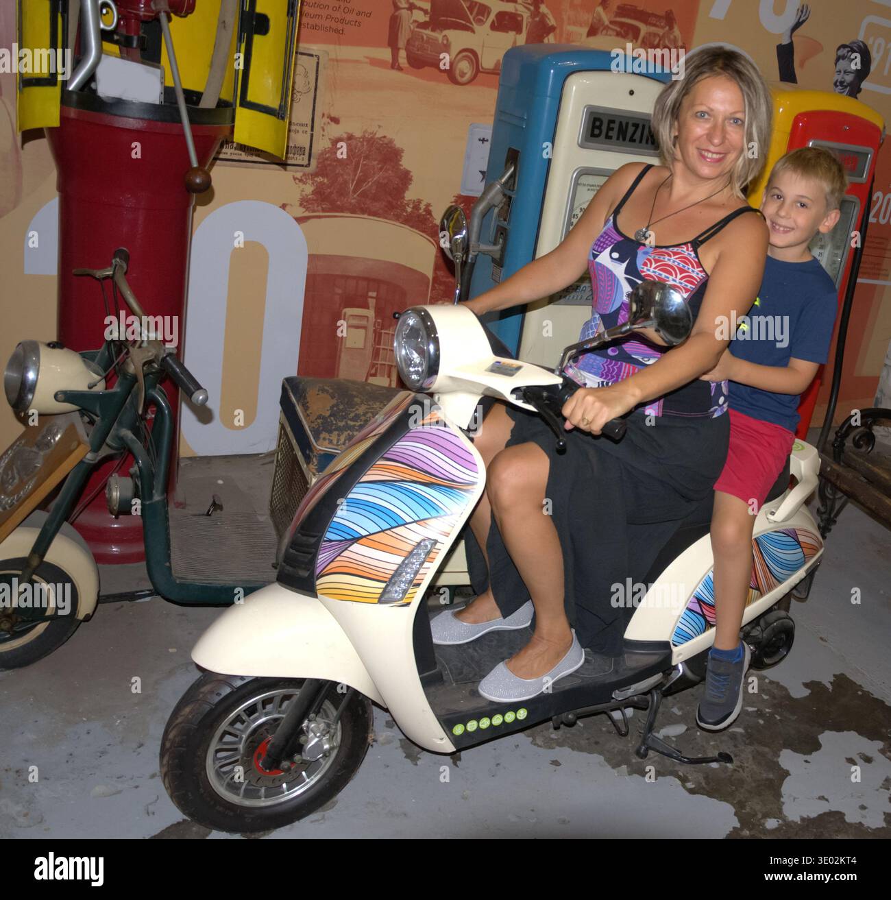 Frau und Kind posieren auf einem Oldtimer-Motorroller im Belgrader Automobil-Museum; Immobilien- und Modellveröffentlichung verfügbar. Stockfoto