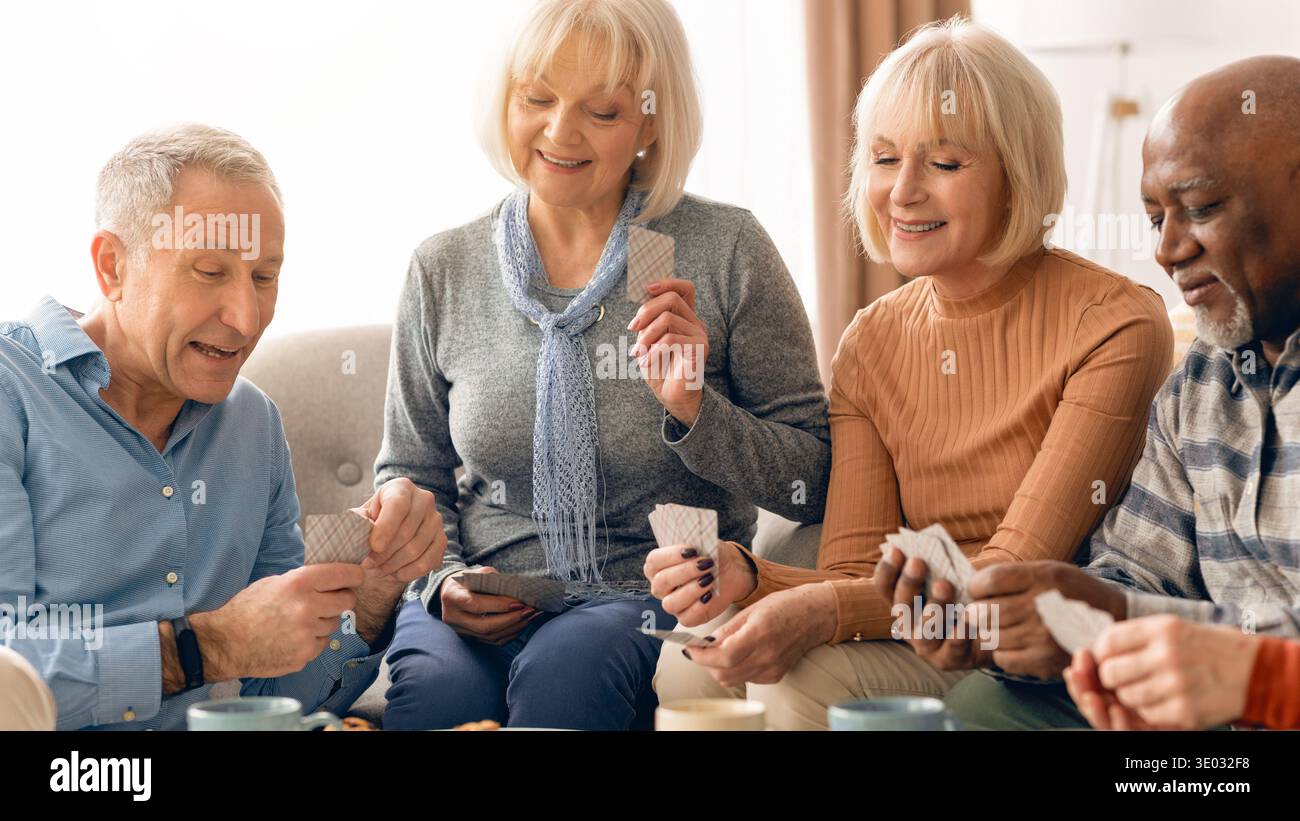 Gruppe von Freunden, die Kartenspiele im Haus während des Nachmittagsversammels genießen Stockfoto