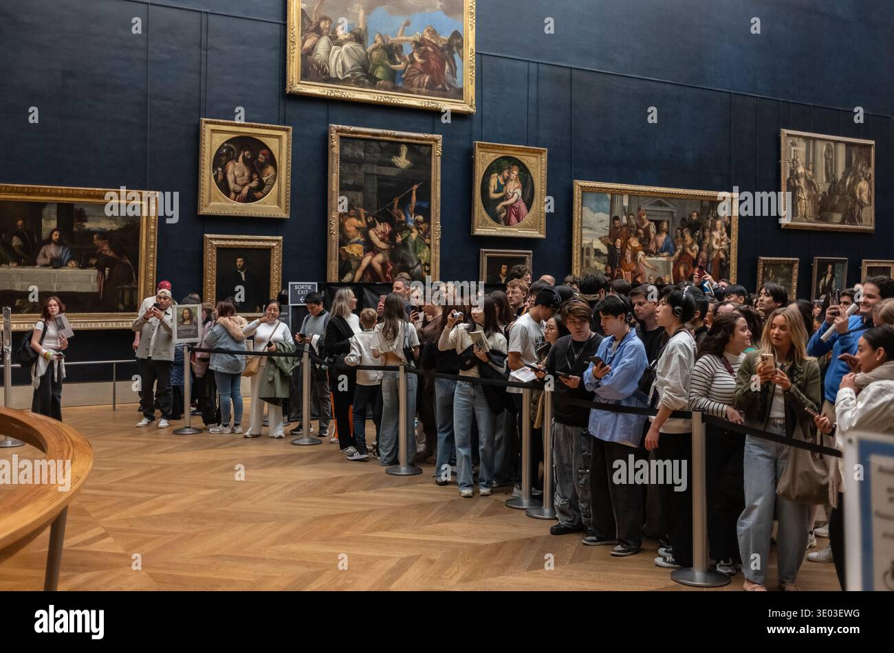 Besucher hinter einer Barriere, die die Mona Lisa von Leonardo da Vinci im Louvre Museum in Paris sehen Stockfoto