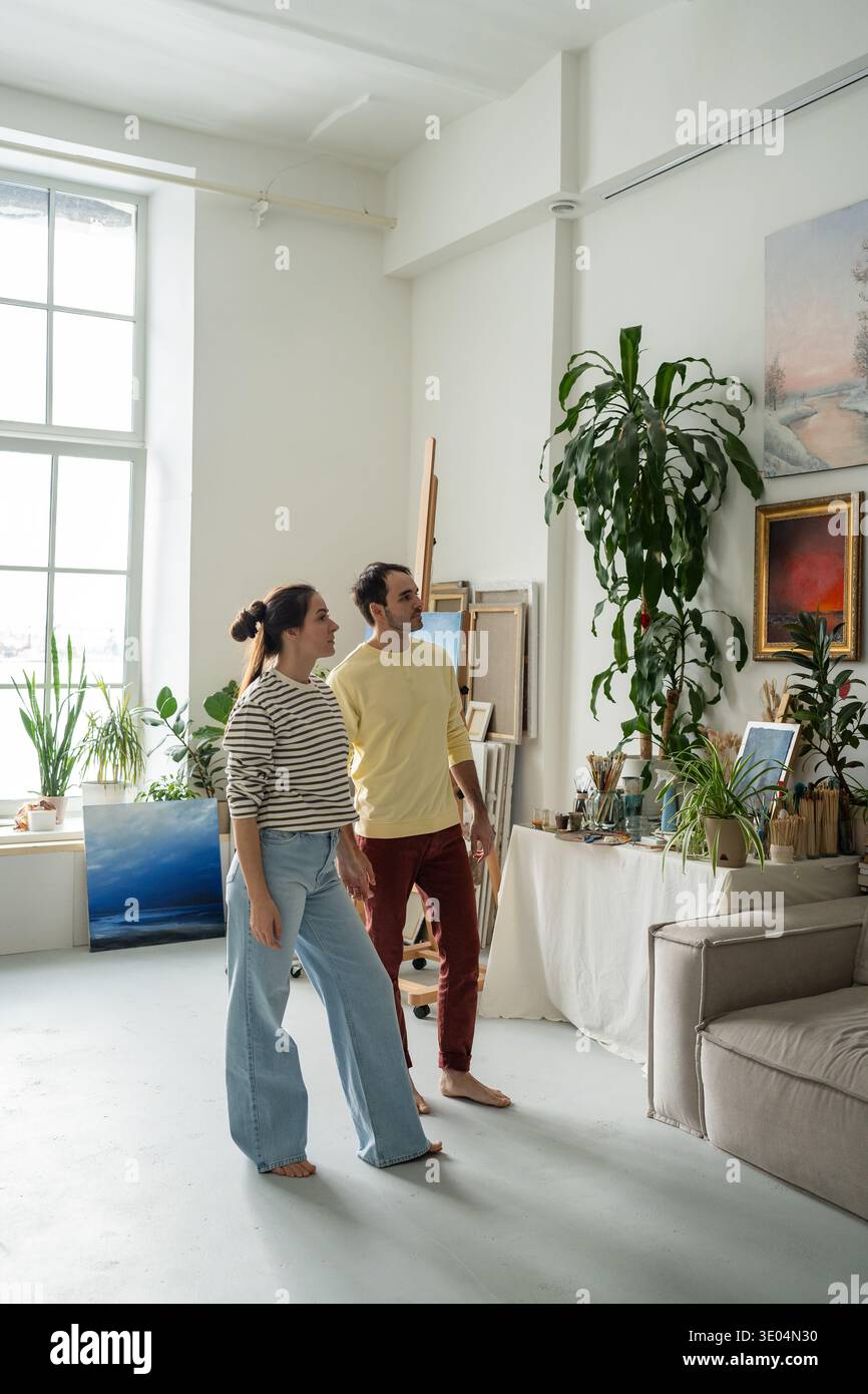 Verheiratete Künstlerpaare, die gemeinsam in der Werkstatt der Galerie Wandgemälde sehen Stockfoto