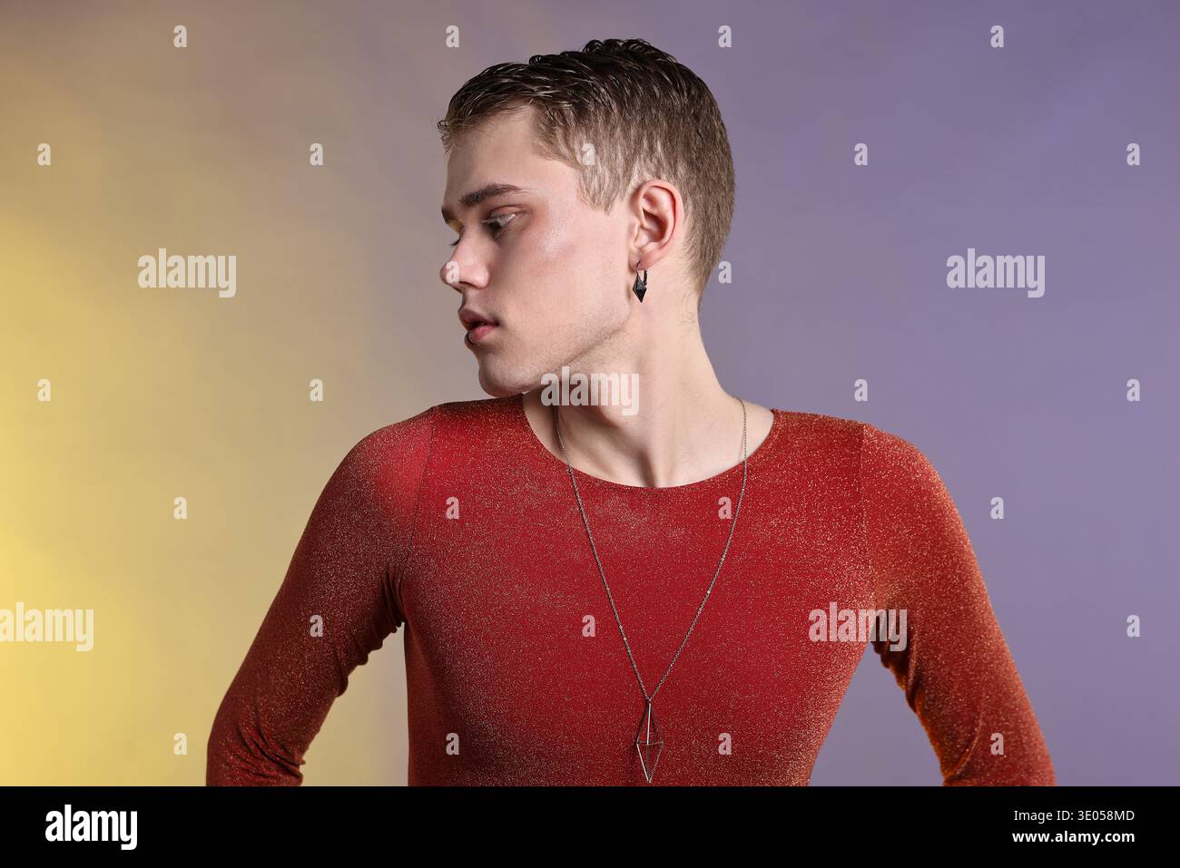 Junger Mann mit Piercing in stilvollem Hemd auf farbigem Hintergrund Stockfoto