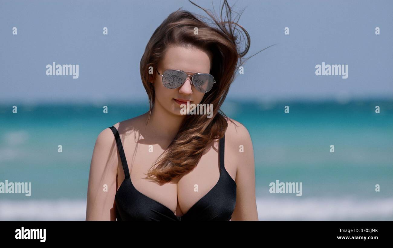 Sommerurlaub und Strandurlaub Eine junge Frau in schwarzem Badeanzug und Fliegersonnenbrille genießt einen tropischen Urlaub an einem sonnigen Tag mit Meerblick Stockfoto