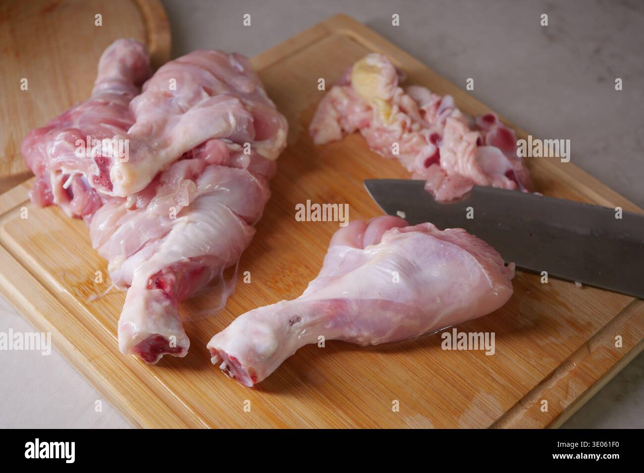 Hühnerteile auf einem hölzernen Schneidebrett in einer Küche Stockfoto