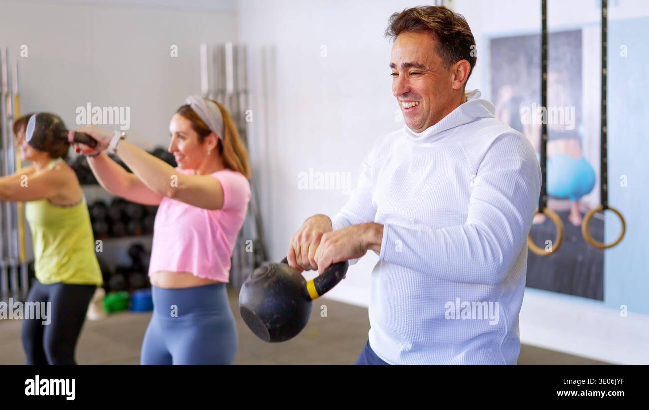 Gruppe von Menschen, die im Fitnessstudio mit Kettlebells trainieren Stockfoto