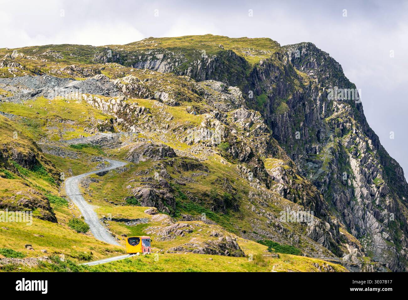 Dramatische Landschaft mit steiler kurviger Straße, die an einem warmen, sonnigen Mittsommertag einen felsigen Berg von Cumbrian hinaufführt. Stockfoto