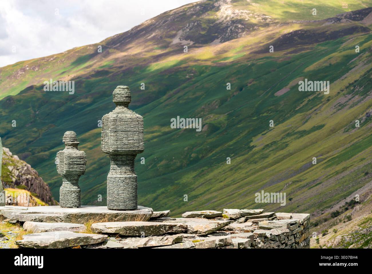 In den Bergen von Cumbrian stehen Statuen mit Blick auf ein malerisches Tal auf steilen Wänden, neben der Honister Slate Mine, einem beliebten Touristenziel und einem Stockfoto
