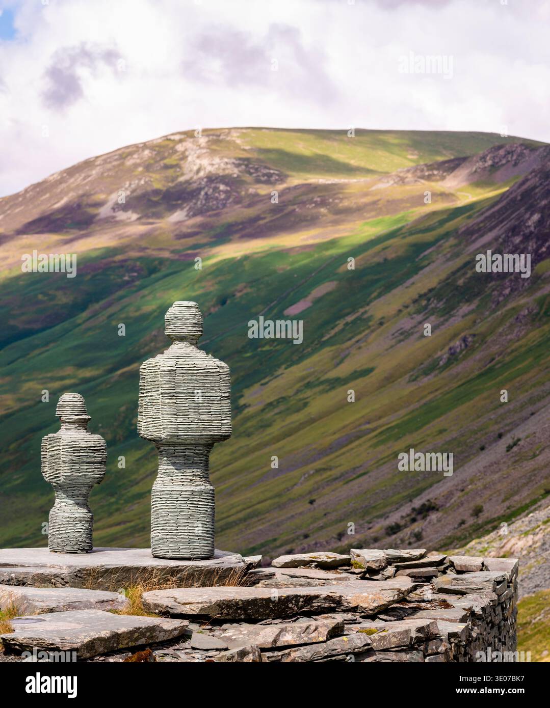 In den Bergen von Cumbrian stehen Statuen mit Blick auf ein malerisches Tal auf steilen Wänden, neben der Honister Slate Mine, einem beliebten Touristenziel und einem Stockfoto